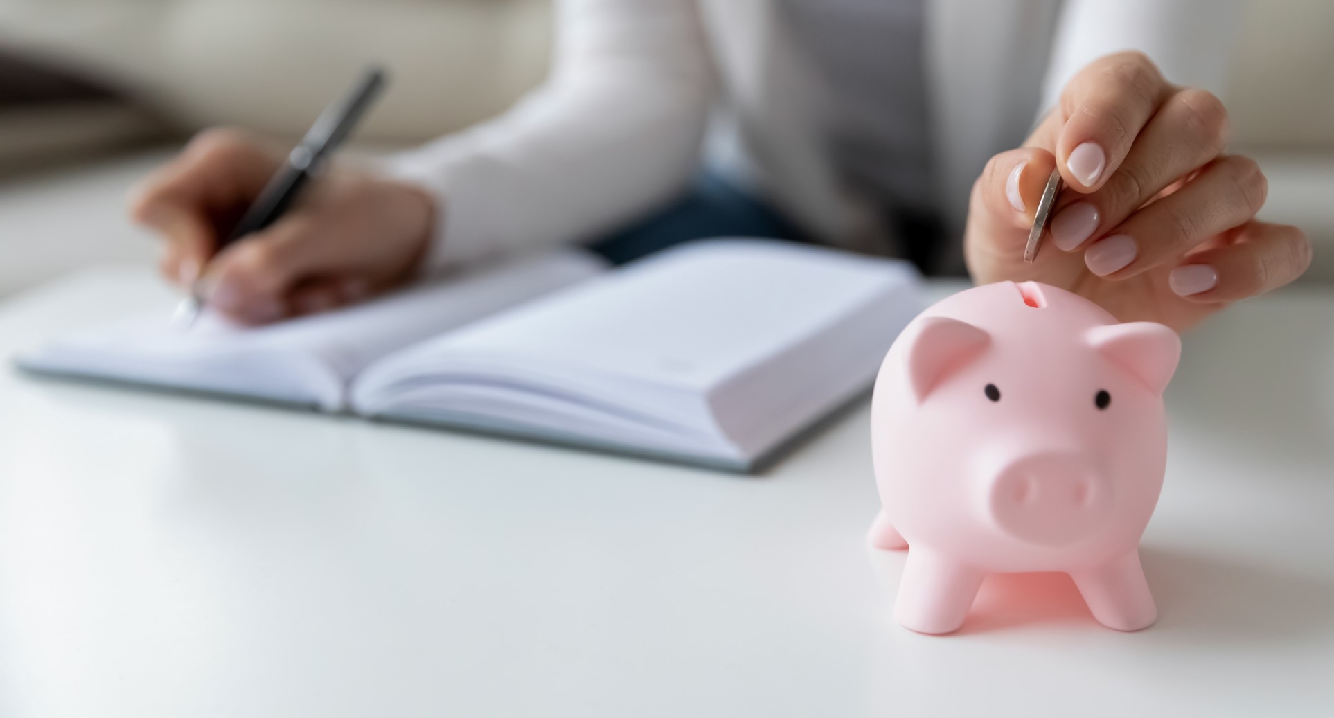 Woman putting coin in piggy bank