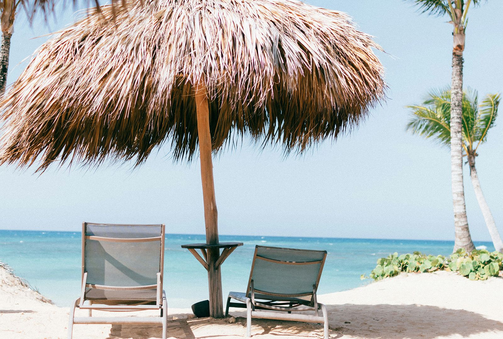 Beach chairs under an umbrella on a tropical beach