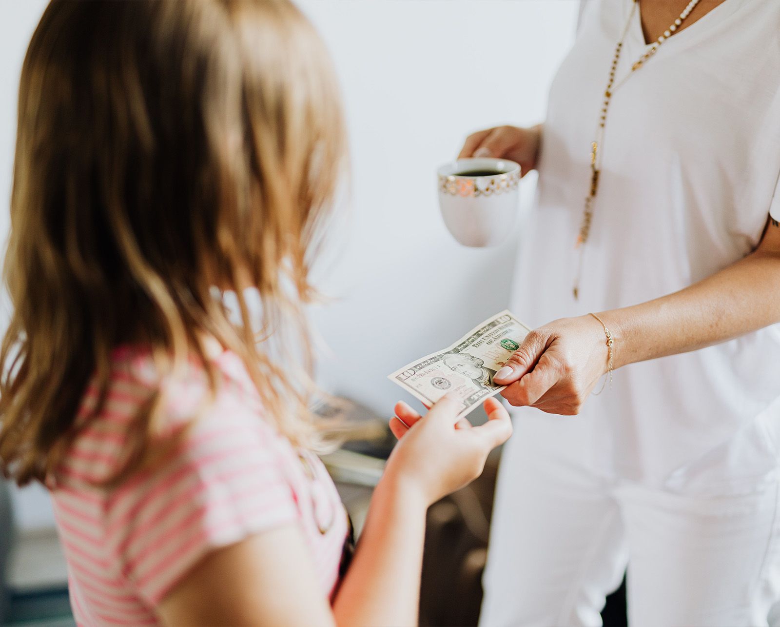 Parent handing a $10 bill to their child